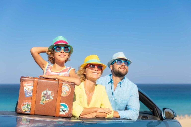 Family Travel Safety. Happy family travel by car at the sea. Mother, father and daughter having fun in blue cabriolet. Summer vacation concept
